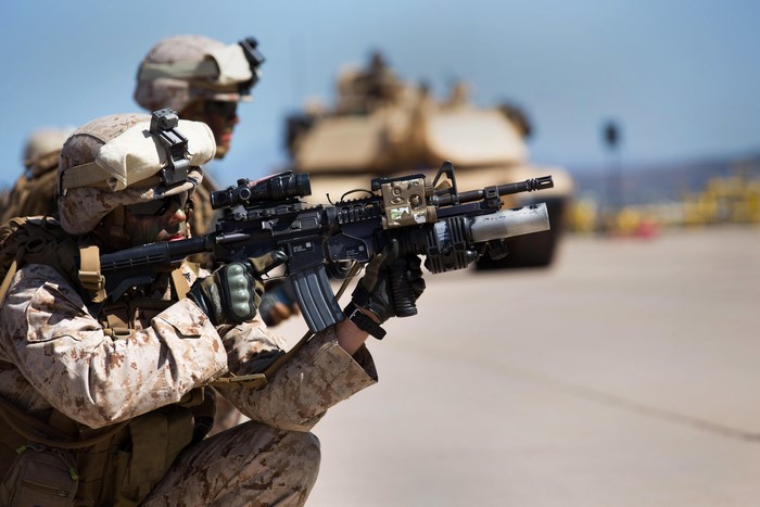 Soldiers with rifles and a tank