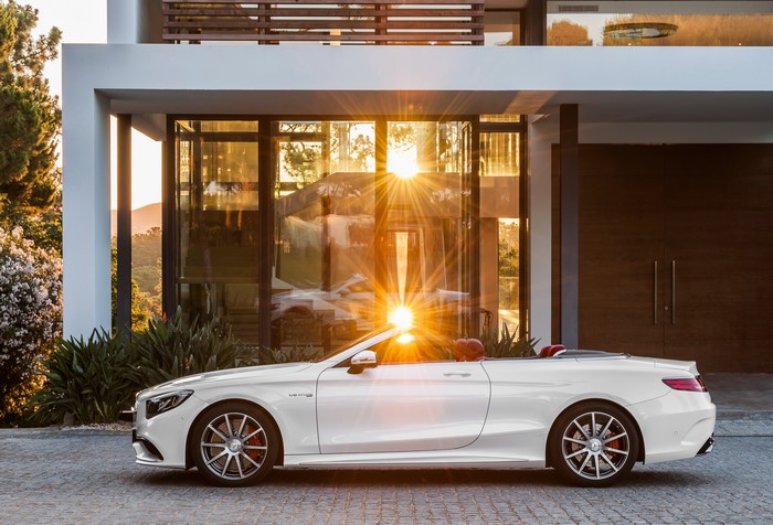 White Mercedes-Benz S 63 Cabriolet parked in front of a modern house