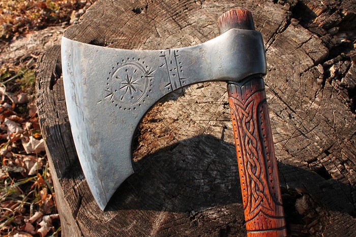 Close-up of a Viking battle axe on a tree stump