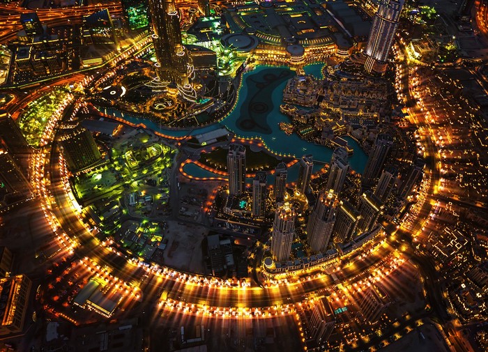Aerial view of Dubai at night with illuminated skyscrapers