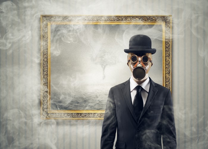 Man in gas mask and suit with framed artwork