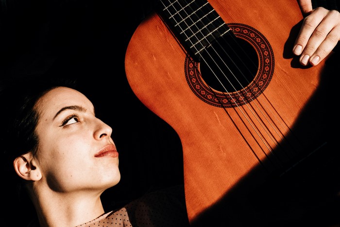 Woman looking up at a guitar