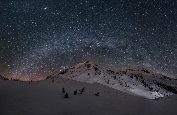 Milky Way over snow-covered mountains at night