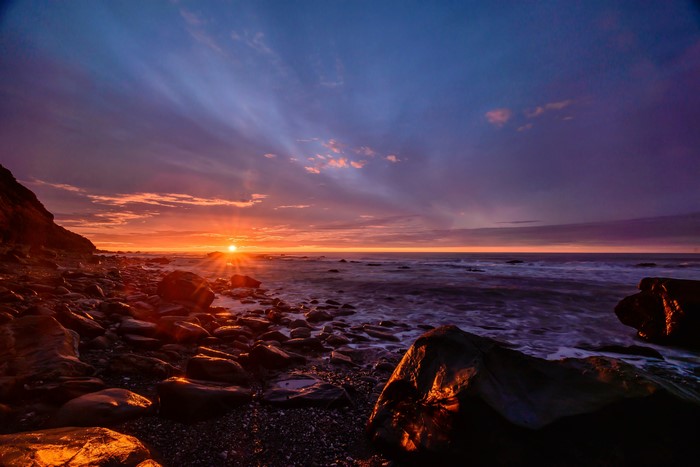 Sunset over rocky New Zealand coastline