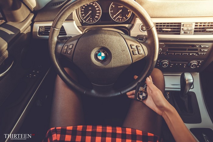 Woman holding BMW keys in a car