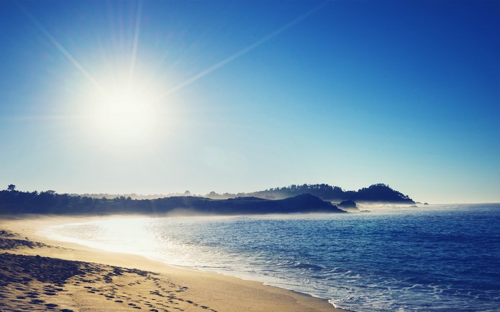 Sunny beach with ocean waves and coastline