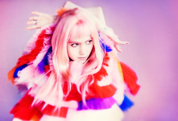 Grimes Claire Boucher with pink hair and colorful fur