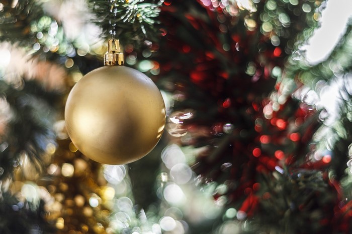 Gold Christmas ornament on a decorated tree