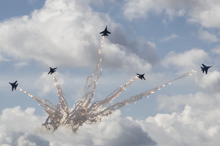 Fighter jets performing aerobatics with flares