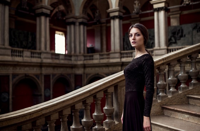 Woman in black dress on ornate staircase