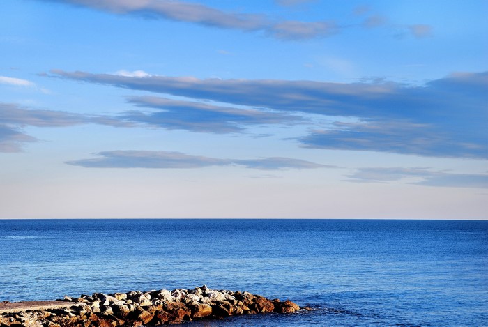Ocean horizon with clouds and rocky shore