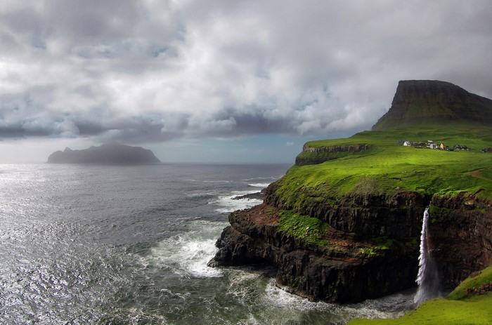 Faroe Islands coastal landscape with waterfall and village