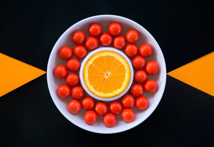 Orange slice and candies in a bowl