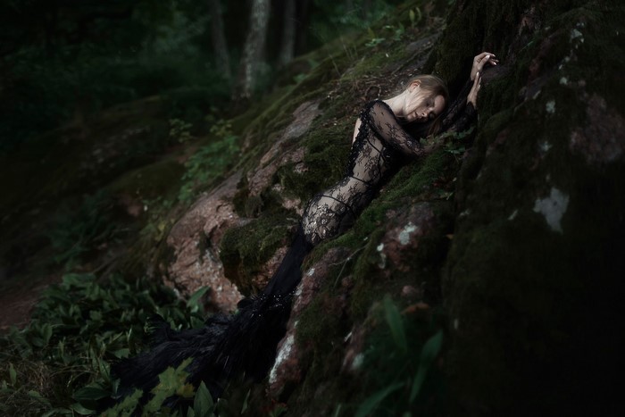 Tatiana Mercalova in a black lace dress on mossy rocks