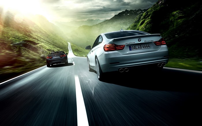 Two BMW Alpina 4 Series cars on a mountain road