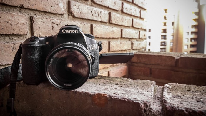 Canon EOS 60D DSLR camera on a brick wall
