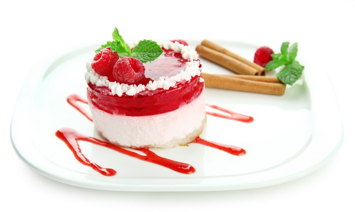 Raspberry cake with cinnamon sticks on a plate