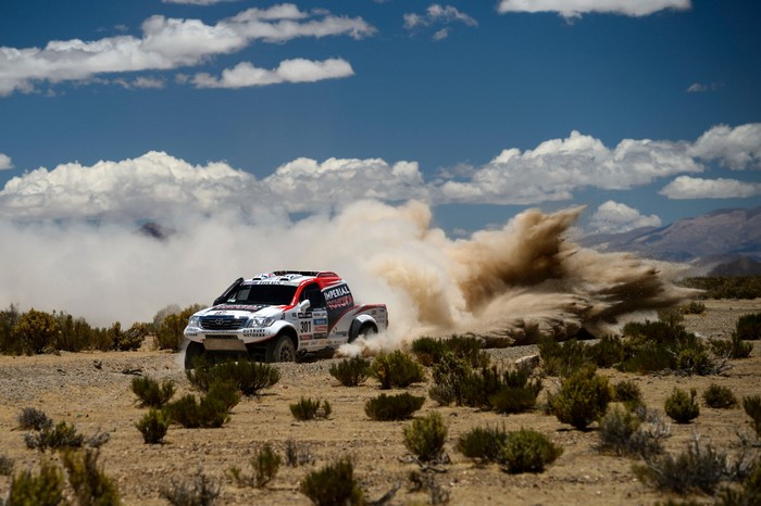 Toyota Hilux racing through dust clouds