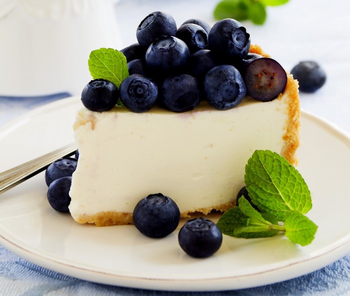 Slice of blueberry cheesecake with mint