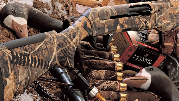 Benelli shotgun with camouflage, cartridges, and duck decoys