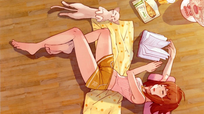 Girl reading a book with a cat sleeping