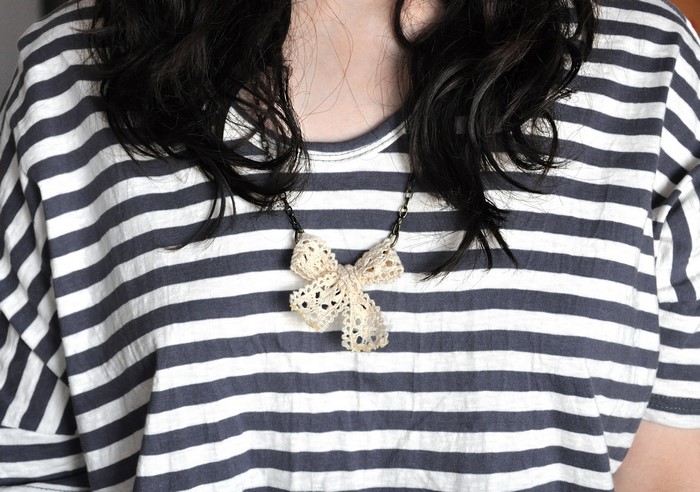 Woman wearing striped shirt and bowknot necklace