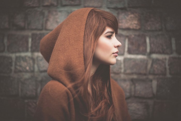 Woman with brown hair wearing a brown hood