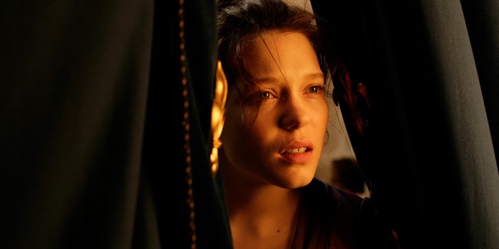 Woman peeking through dark curtains