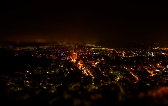 Cityscape at night from above with illuminated buildings