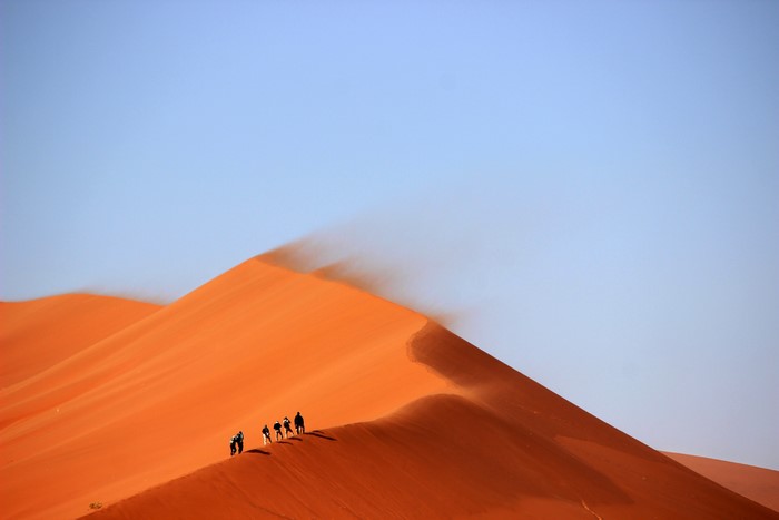 People walking on sand dunes in the desert
