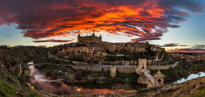 Toledo, Spain, with a castle and river at sunset