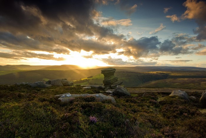 Sunset over rocky hills with dramatic clouds