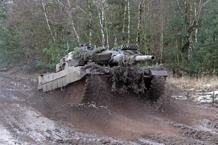 Tank driving through mud in a forest