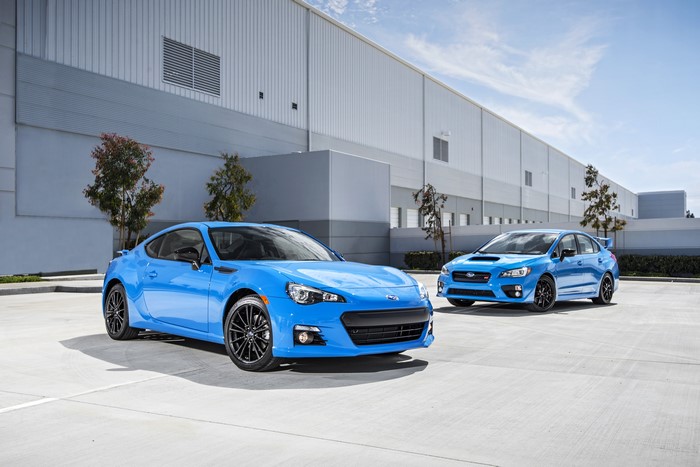 Two blue Subaru cars parked outside a building