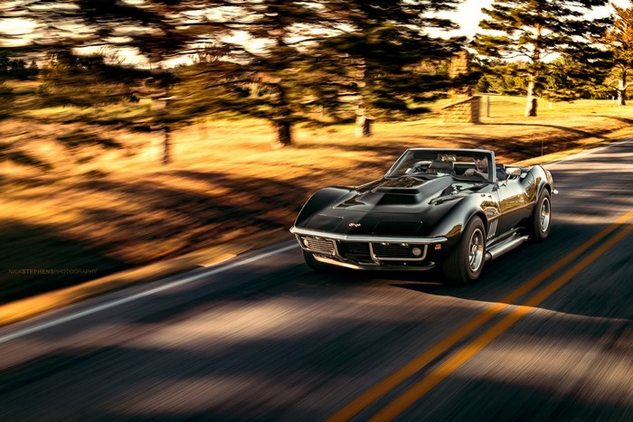 Black Chevrolet Corvette Stingray driving on a road