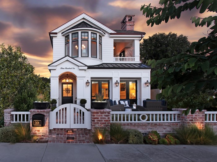 White house with brick fence and garden