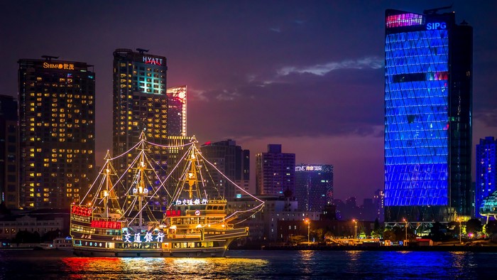 Shanghai skyline with illuminated buildings and a pirate ship at night