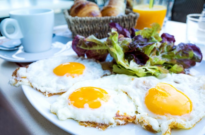 Fried eggs with salad and coffee