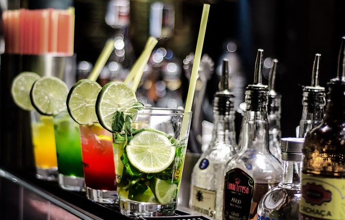 Cocktails with lime slices and mint on a bar counter