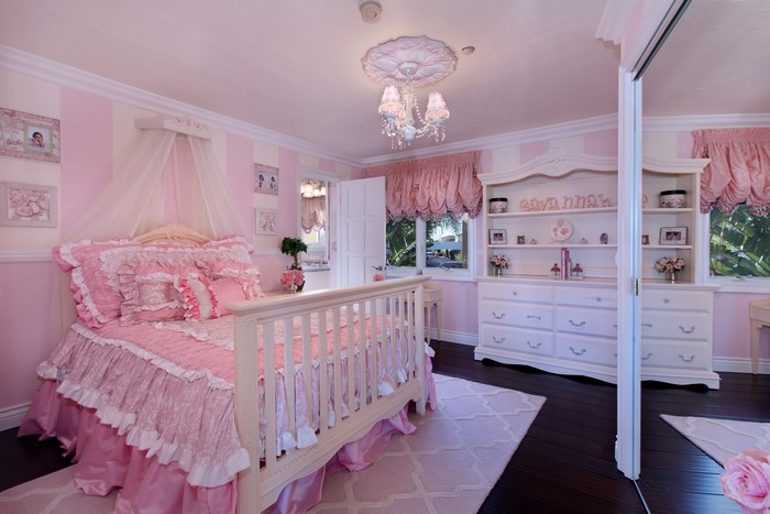Pink and white striped girl's bedroom with canopy bed and dresser