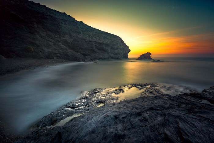 Rocky coast at sunset with ocean waves