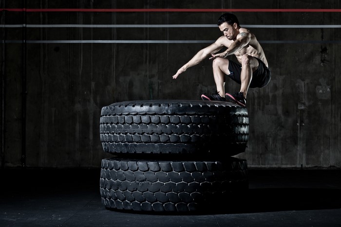 Man performing a tire jump workout
