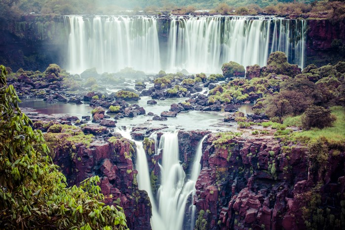 Waterfalls cascading over rocky cliffs with lush greenery