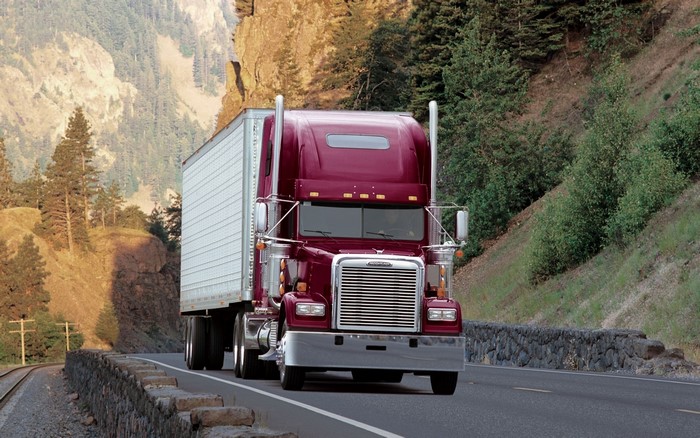 Maroon Freightliner Semi-Truck Driving on a Mountain Road