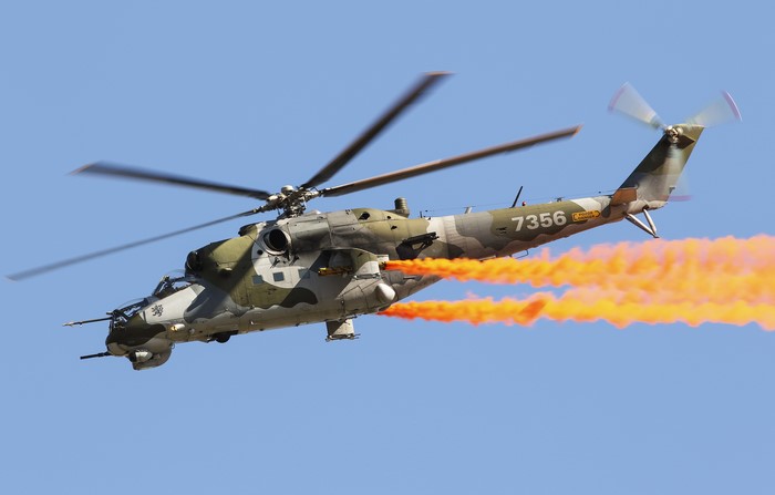 Mil Mi-24V helicopter with orange smoke
