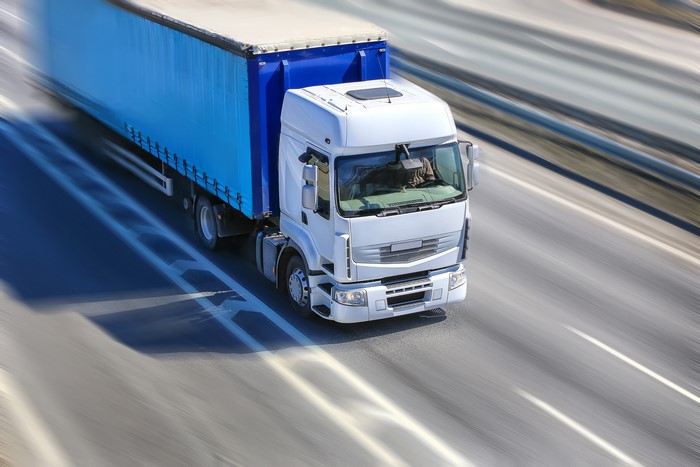 White Truck with Blue Trailer in Motion