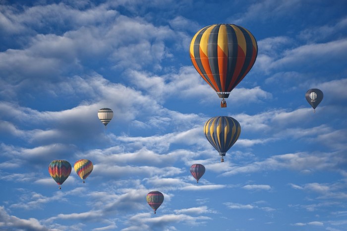 Hot air balloons in a cloudy blue sky