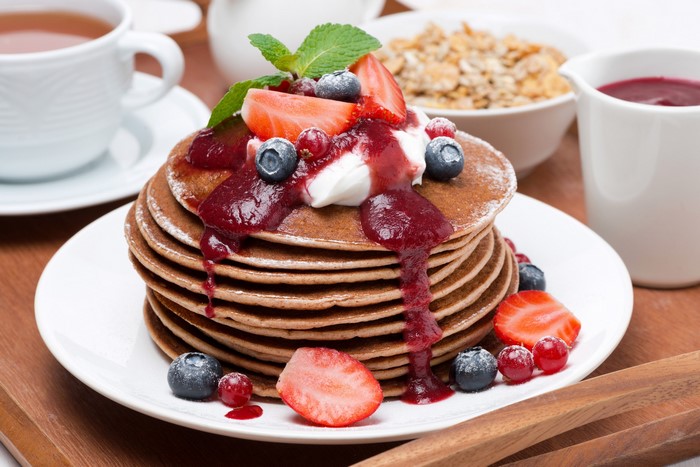 Stack of pancakes with berries and jam