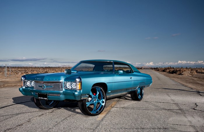 1971 Chevrolet Impala with custom rims on a road