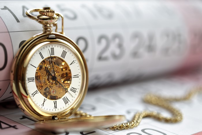 Gold pocket watch on a calendar